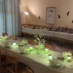 Gedeckter Tisch mit Büffet im Hintergrund