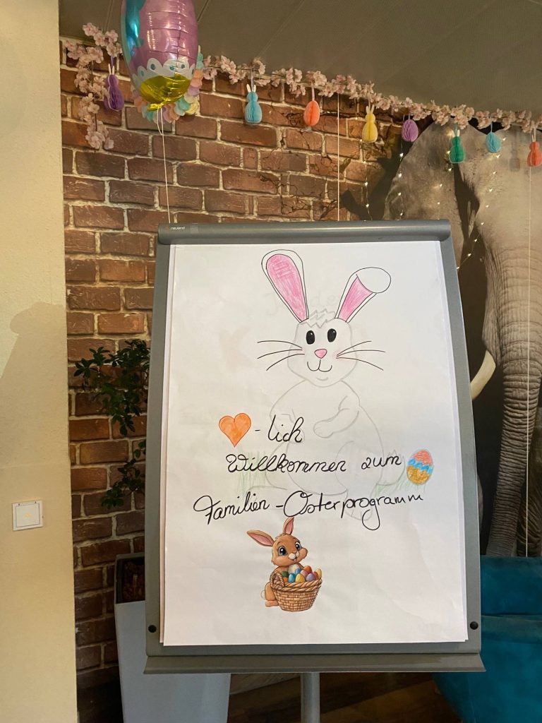 Selbstgemaltes Schild Herzlich Willkommen zum Familien-Osterprogramm