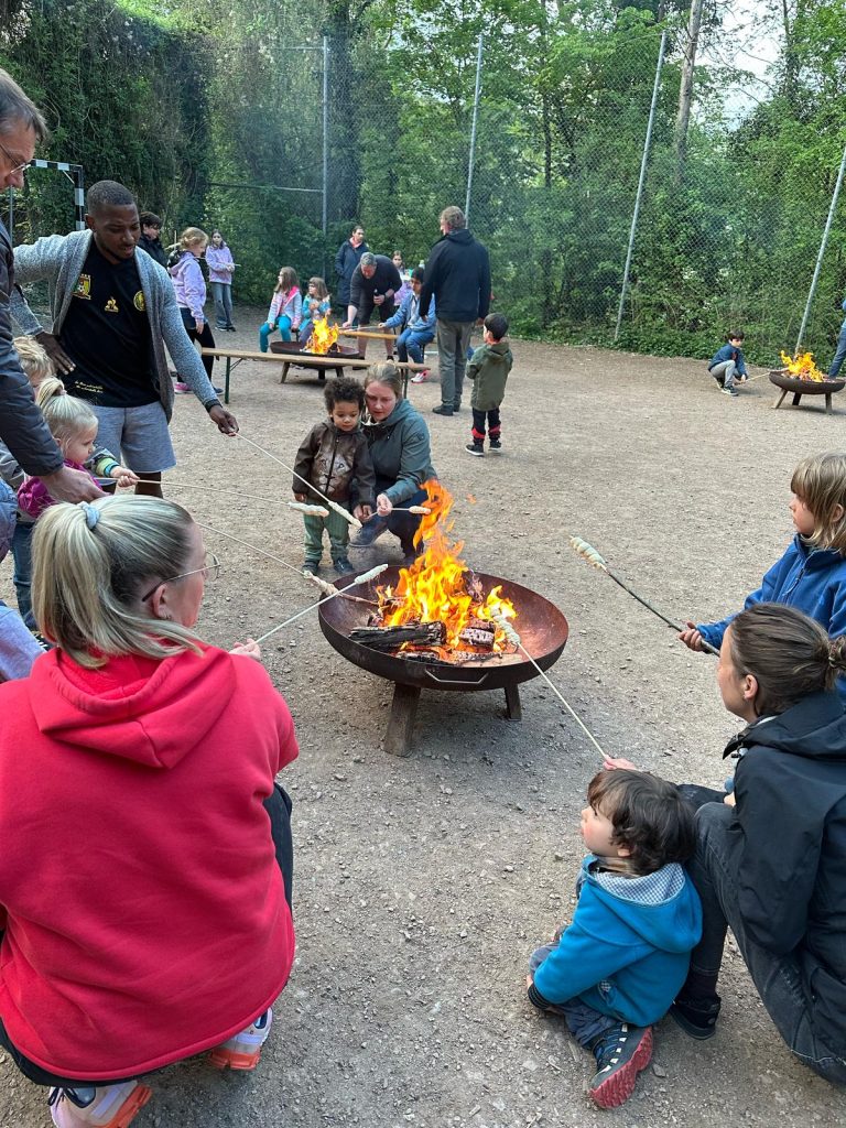 Familien am Feuer mit Stockbrot