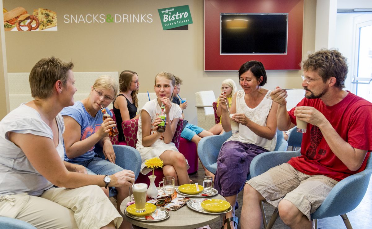 Eine Familie genießt im Bistro der Jugendherberge Leutesdorf verscheiden heiß Getränke.
