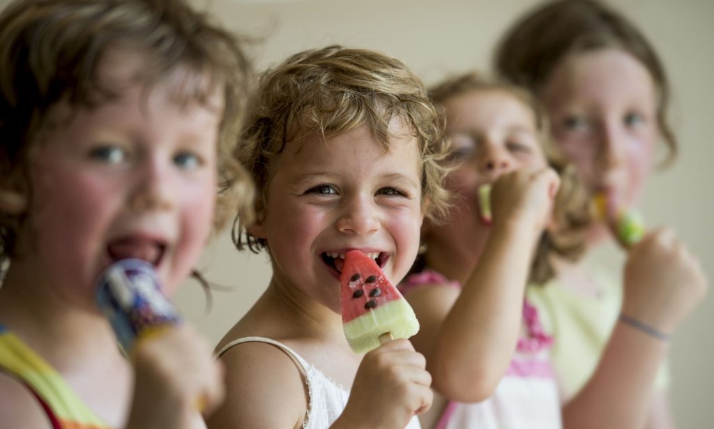 Vier Mädchen essen glücklich Eis 