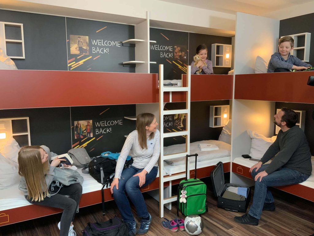 Eine Familie sitzt auf den Betten im Zimmer der Jugendherberge St. Goar
