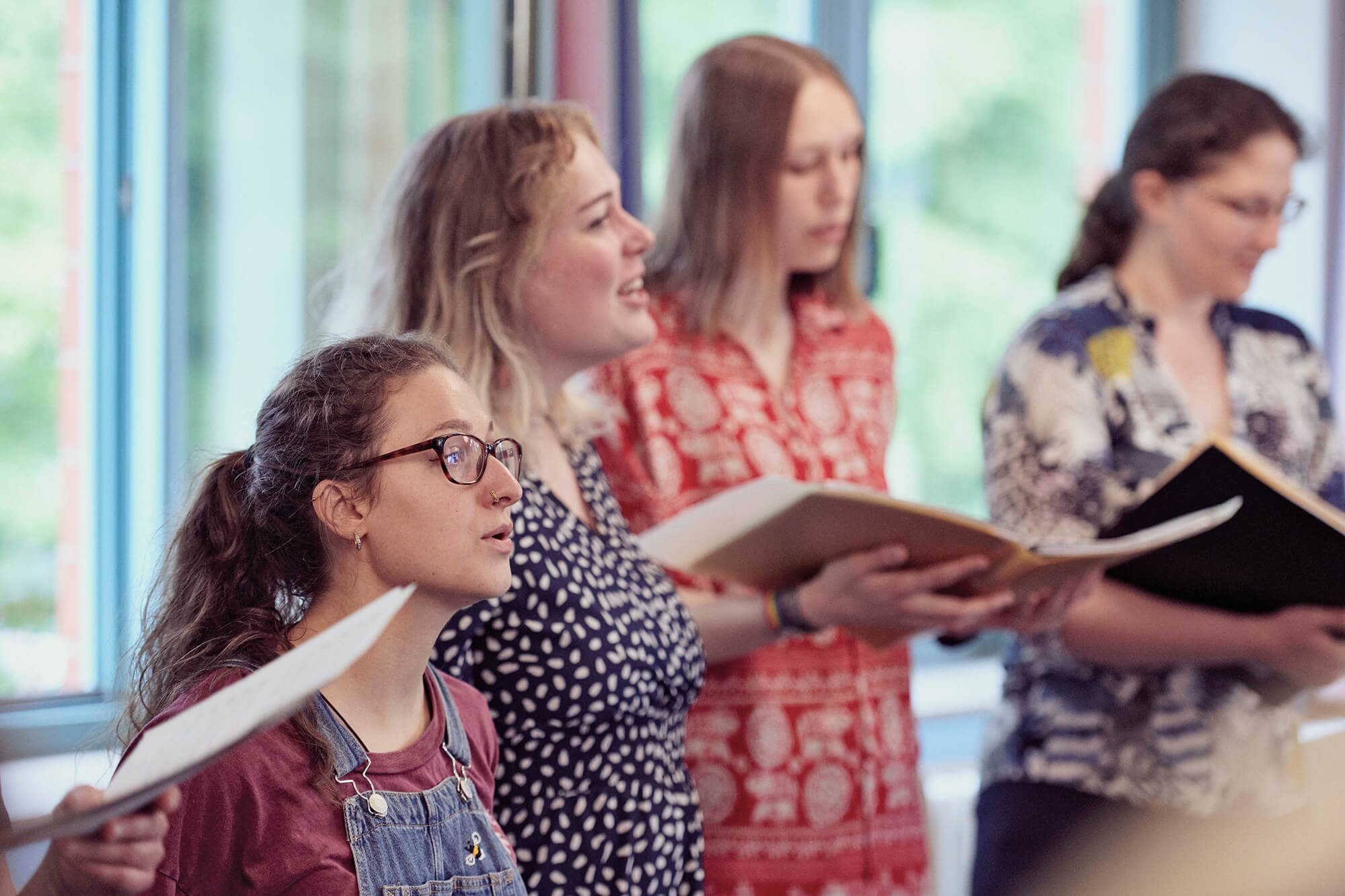 Vier Frauen halten Noten und singen