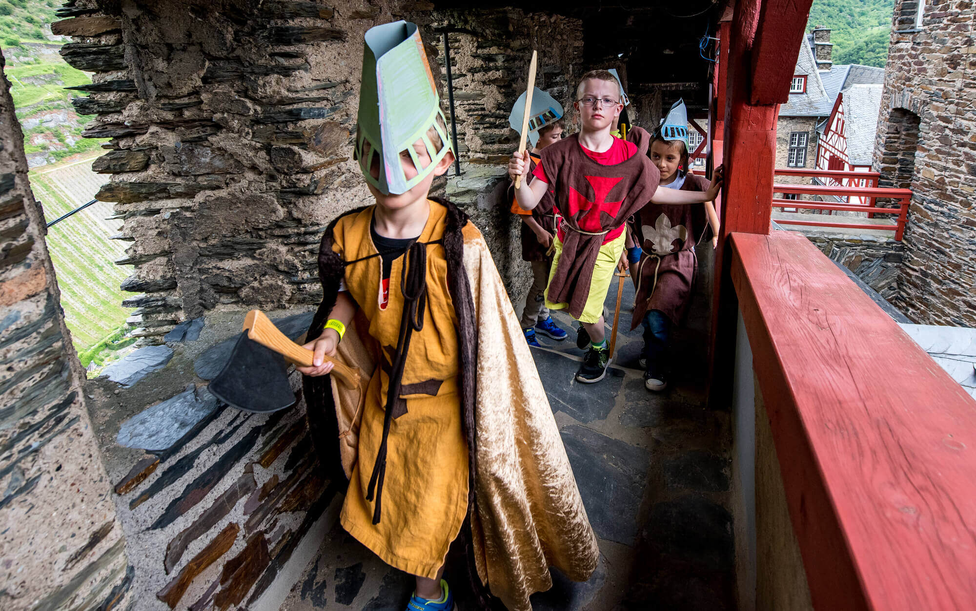 Beim Klassenfahrtprogramm sind Jungen als Ritter verkleidet laufen durch den Wehrgang der Burg