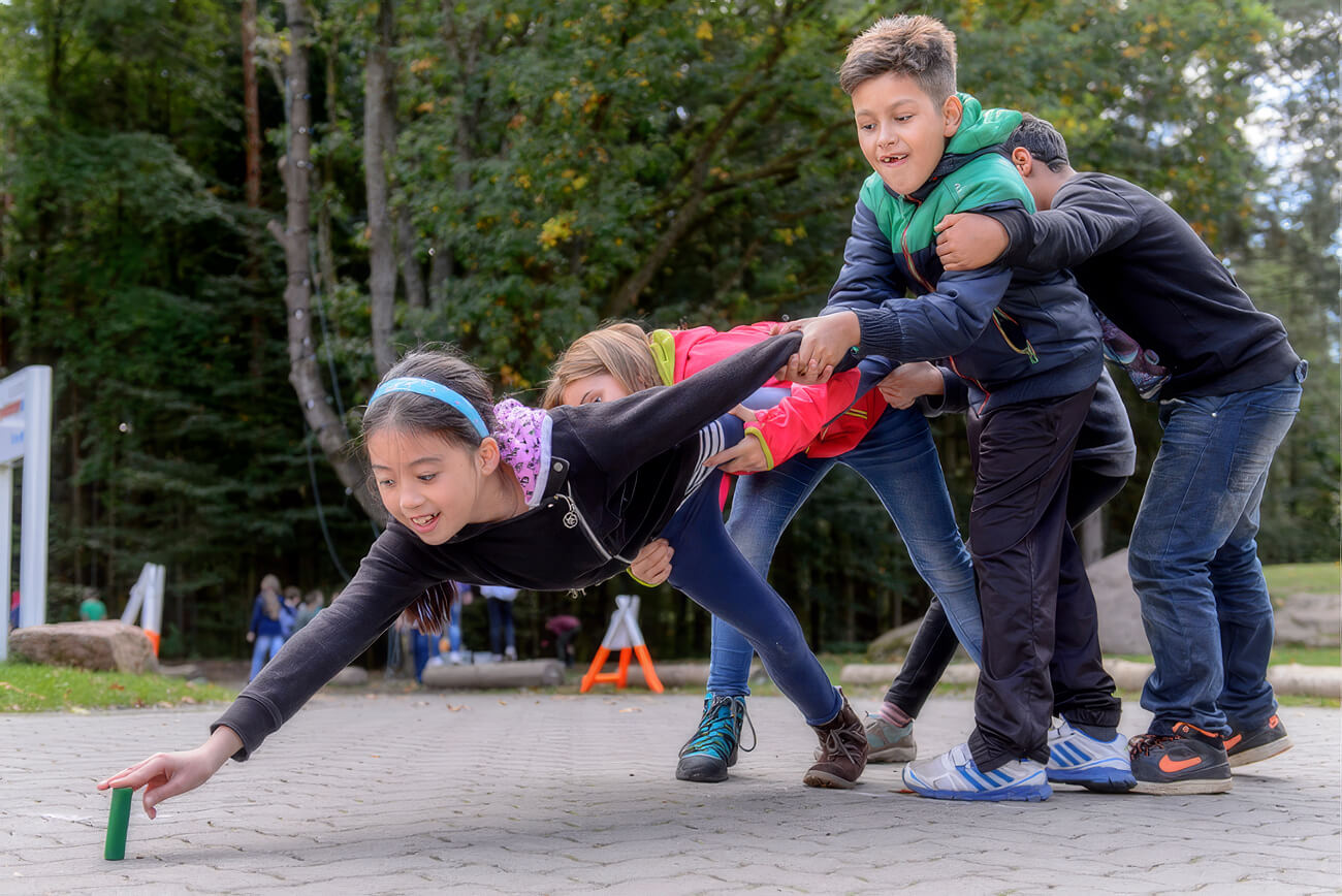 Schüler lösen gemeinsam eine Teamaufgabe beim Erlebnisprogramm in der Jugendherberge.