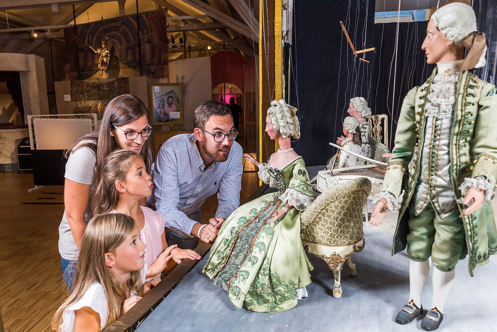 Eine Familie schaut sich Puppen im Museum an 