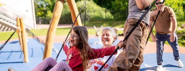 Familie schaukelt auf dem Spielplatz der Jugendherberge Mainz