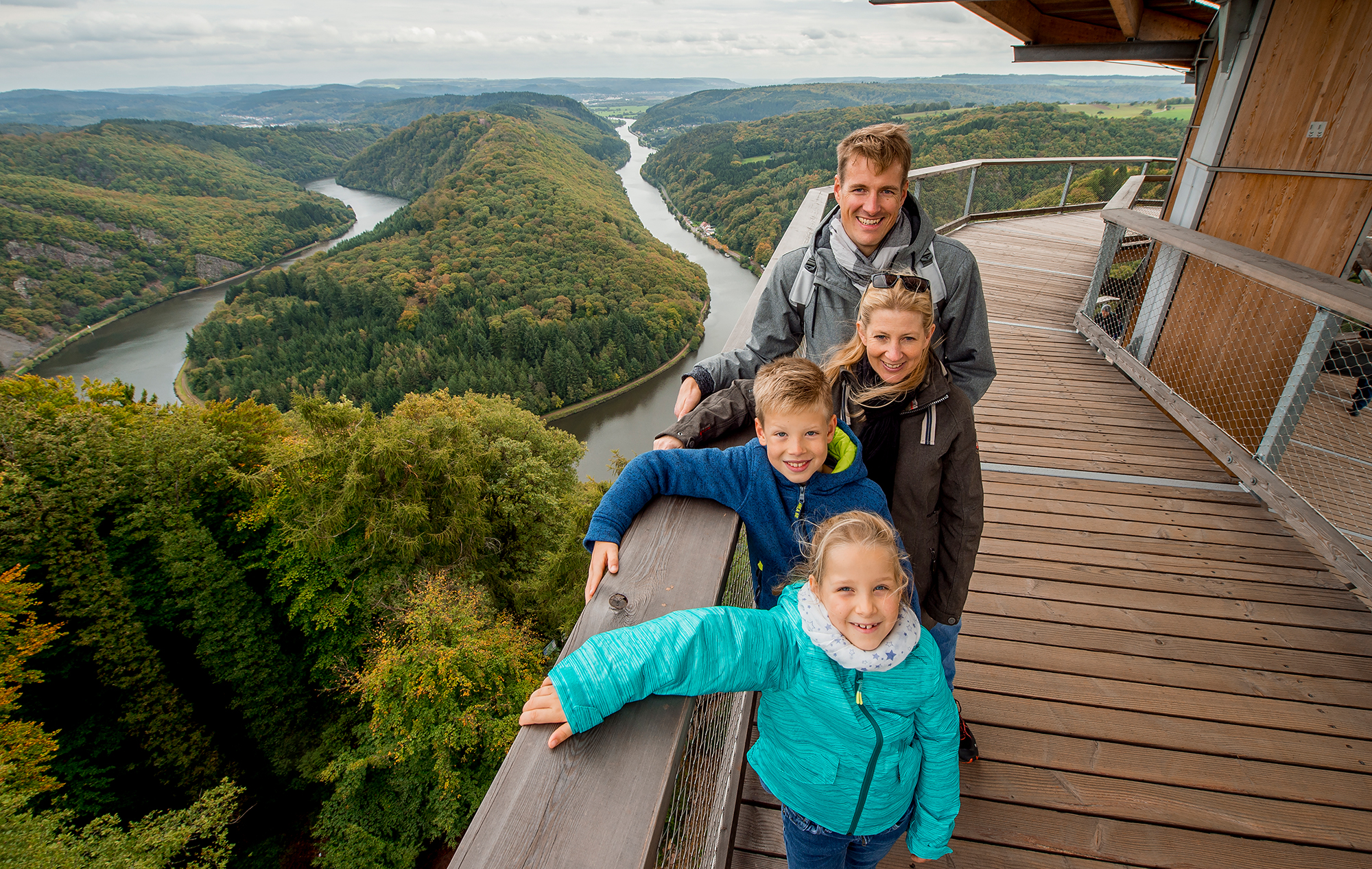 Eine Familie auf dem Baumwipfelpfad mit Blick auf die Saarschleife.