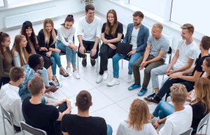 Eine Gruppe sitzt im Stuhlkreis zusammen