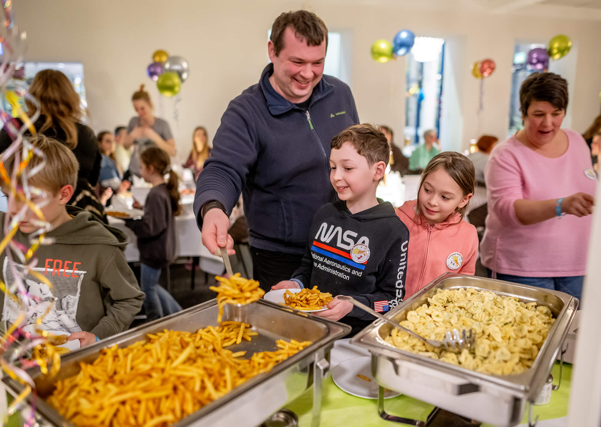 Eine Familie steht am Büffet der Jungherberge Trier und freut sich auf die kulinarischen Highlights