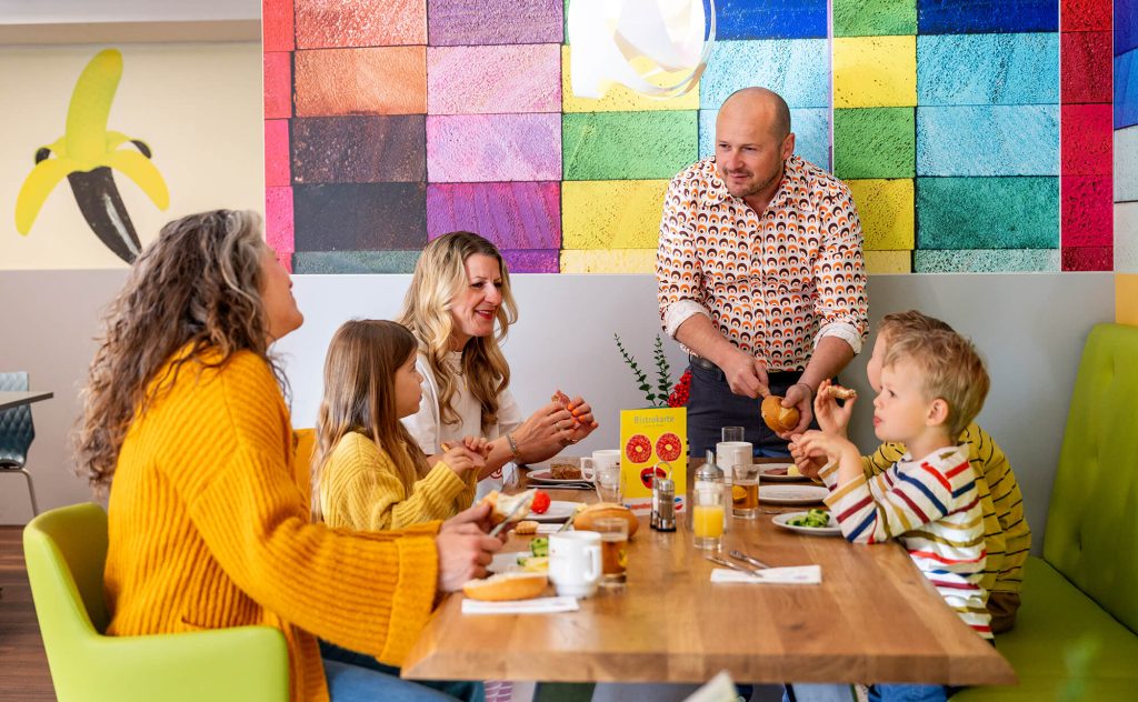 Eine Familie frühstückt fröhlich in der Jugendherberge Mainz